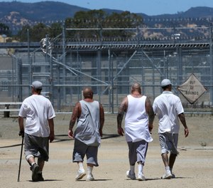 In this photo taken June 20, 2018, inmates walk the exercise yard at the California Medical Facility in Vacaville, Calif.