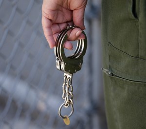 A CO holds a pair of handcuffs at San Quentin State Prison Tuesday, Aug. 16, 2016, in San Quentin, Calif.
