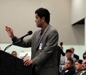 Los Angeles police Chief Charlie Beck, right, closes his eyes as Francisco Ortega, a human relations analyst, tries to calm the crowd during a community meeting in Los Angeles, Wednesday, Sept. 8, 2010.