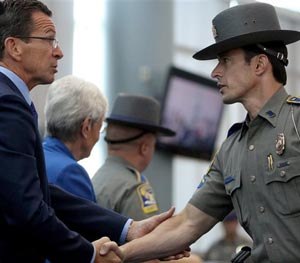 Connecticut Gov. Dannel P. Malloy, left, shakes the hand of State Police detective Thomas Kiely during a ceremony honoring responders to the Sandy Hook Elementary School shooting in December 2012 at Rentschler Field in East Hartford Conn., Tuesday July 8, 2014.