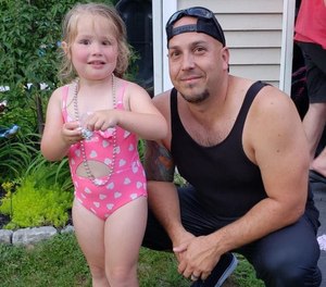 Clarkstown police officer Paul Munding with 4-year-old Ella after saving her from drowning at a pool party in Rockland County, N.Y. July 5, 2020. (Photo/Carly Shaffer via Clarkstown Police Department)