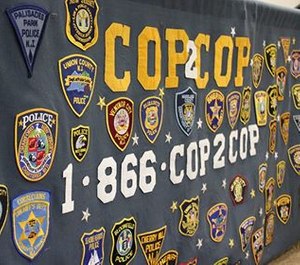 A banner displays Cop2Cop's helpline number.