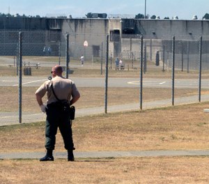 In this Aug. 17, 2011 file photo, a correctional officer keeps watch on inmates in the recreation yard at Pelican Bay State Prison near Crescent City, Calif. (AP Photo/Rich Pedroncelli)