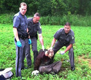 Police stand over David Sweat after he was shot and captured near the Canadian border Sunday, June 28, 2015, in Constable, N.Y.
