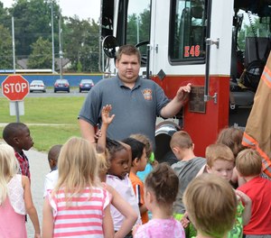 Firefighter Corey Spencer shows young visitors around the Pinecroft Sedgefield Fire Department in 2015.