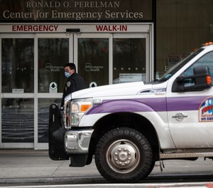 An NYPD officer wearing a protective face mask monitors the outside of the NYU Langone Hospital Emergency room entrance in New York.