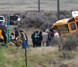 Emergency personnel help to remove passengers from the school bus.