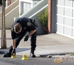 A San Francisco Police officer places a marker on the street after shootings in San Francisco, Wednesday, Nov. 1, 2017.
