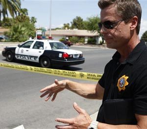 Las Vegas police Sgt. John Sheahan speaks to the media at the scene of a home invasion and shooting in Las Vegas on Tuesday, July 29, 2014. (AP Image)