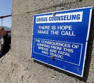 In this file photo taken Tuesday, April 30, 2013, a sign is posted above a crisis counseling call box on the Golden Gate Bridge in San Francisco.