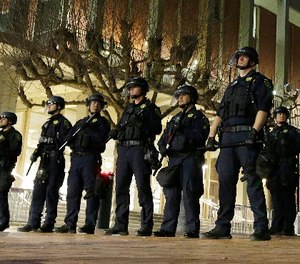 In this Feb. 1, 2017 file photo, University of California, Berkeley police guard the building where Breitbart News editor Milo Yiannopoulos was to speak. (AP Photo/Ben Margot, File)