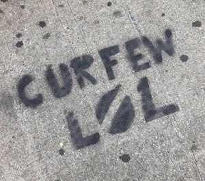 A sidewalk is spray painted with graffiti about New York City's curfew order, in the Brooklyn borough of New York, Tuesday, June 2, 2020. (AP Photo/Mark Lennihan)
