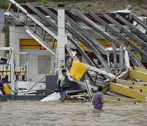 People walk next to a gas station flooded and damaged by the impact of Hurricane Maria, which hit the eastern region of the island, in Humacao, Puerto Rico. (Photo/AP)