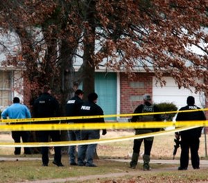 Police officers work the scene where two St. Louis County officers were shot and a man barricaded himself inside a home on Thursday, Dec. 14, 2017, in the St. Louis County town of Bellefontaine Neighbors, Mo.