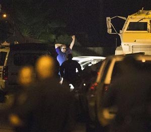 Law enforcement officers surround a shooting suspect Wednesday, July 9, 2014, in Spring, Texas.