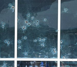 Bullet holes are seen in the side of the Dallas Police headquarters after an early morning attack on police by a gunman Saturday, June 13, 2015, in Dallas.