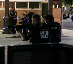 In this July 7, 2016, file photo, Dallas police move to detain a driver after several police officers were shot in downtown Dallas.