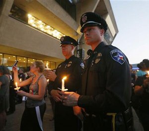 A Dallas Area Rapid Transit police officer receives comfort at the Baylor University Hospital emergency room entrance Thursday, July 7, 2016, in Dallas. Police say one rapid-transit officer has been killed and three injured when gunfire erupted during a protest in downtown Dallas over recent fatal shootings by police in Louisiana and Minnesota.