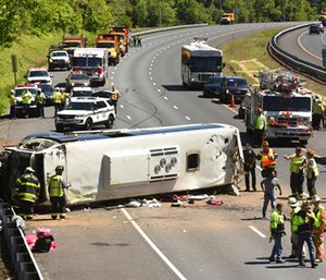 Emergency workers tend to an overturned bus on I-95 southbound. (Amy Davis/The Baltimore Sun via AP)