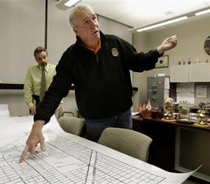 In this Dec. 11, 2012 file photo, Jack Riley, center, head of the Drug Enforcement Administration in Chicago, points out local Mexican drug cartel problem areas on a map in Chicago.