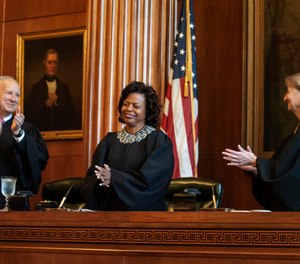 In this March 7, 2019, file photo, Associate Justices Paul Newby, left, and Robin Hudson, right, applaud for new Chief Justice Cheri Beasley of the N.C. Supreme Court during Beasley's investiture ceremony in Raleigh, N.C. (Paul Woolverton/The Fayetteville Observer via AP, File)