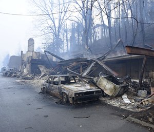 A structure and vehicle are damaged from the wildfires around Gatlinburg, Tenn., on Tuesday, Nov. 29, 2016. (Michael Patrick/Knoxville News Sentinel via AP)