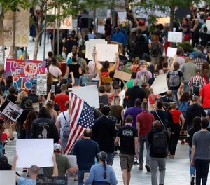 Protesters walk down the 16th Street mall during a protest over the death of George Floyd, a handcuffed black man who died in police custody in Minneapolis, Thursday, May 28, 2020, in Denver.