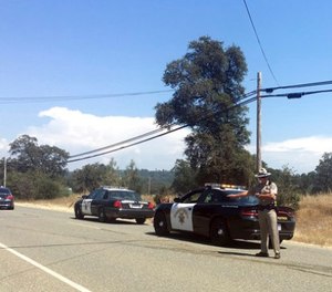 Officers search for a suspect after a shooting in Dobbins, Calif., Tuesday, Aug. 1, 2017.