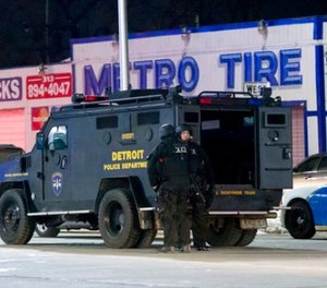 In a Wednesday, March 15, 2017 photo, Detroit police gather at the staging area near Ash and Tillman in Detroit for the search a suspect wanted in the shooting of two Detroit police officers.