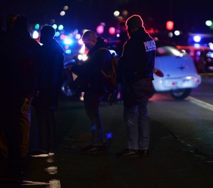 Detroit Police officers gather where one officer was fatally shot and another was wounded while responding to a home invasion on Detroit’s West Side, late Wednesday night. (Photo/AP)