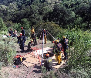 Rescue workers help rescue a dog out of a well in the mountains outside of Malibu, Calif. (Los Angeles County Fire Department via AP)