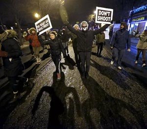 Protesters march during a rally near the Chicago Police headquarters after the announcement of the grand jury decision not to indict police officer Darren Wilson in the fatal shooting of Michael Brown, an unarmed black 18-year old, Monday, Nov. 24, 2014, in Chicago.