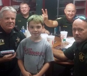 This picture captures Tyler Carach posing with the very first LEOs he gave donuts to. (Photo/Sheena Carach)