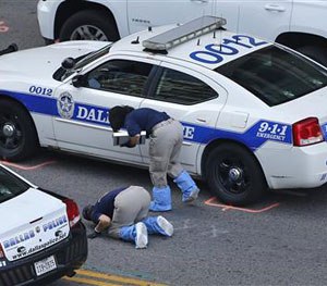 An FBI evidence response team works the crime scene, Sunday, July 10, 2016, where five Dallas police officers were killed Thursday, in Dallas. (AP Image)