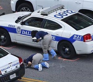An FBI evidence response team works the crime scene, Sunday, July 10, 2016, where five Dallas police officers were killed Thursday, in Dallas.
