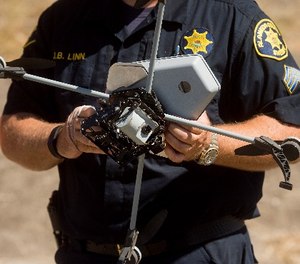 Sgt. Jim Linn retrieves the Alameda County Sheriff's Office drone while demonstrating a search and rescue operation on Friday, Aug. 14, 2015, in Dublin, Calif.