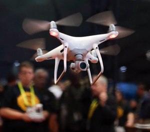 In this Jan. 5, 2017 file photo, an exhibitor demonstrates a drone flight at CES International, in Las Vegas. White House officials said Trump will sign a memorandum Wednesday permitting states, localities and tribes to craft their own pilot programs to test drones. There is no limit on the number of communities that can participate.