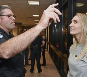 Baton Rouge Police Lt. Greg Fairbanks, left, performs a horizontal gaze nystagmus test on participant Kristin Lear during the department's annual 'drinking lab.' (Photo/TNS)