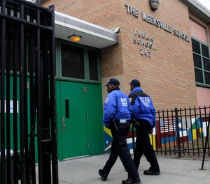 Police officers enter Weeksville School in Brooklyn, New York, Wednesday, Feb. 8, 2012.