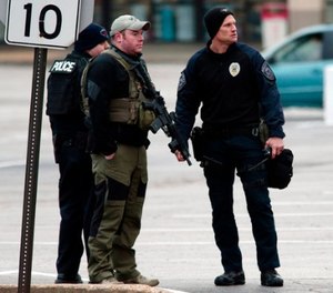 Police officers work the scene where two Bellefontaine Neighbors officers were shot and a man barricaded himself inside a home on Thursday, Dec. 14, 2017, in the St. Louis County town of Bellefontaine Neighbors, Mo. (Robert Cohen/St. Louis Post-Dispatch via AP)