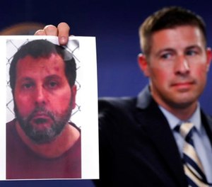 Timothy Wiley, FBI public affairs specialist, holds a photo Amor Ftouhi after a news conference in Detroit, Thursday, June 22, 2017. (AP Photo/Paul Sancya)