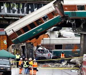Cars from an Amtrak train lay spilled onto Interstate 5 below alongside smashed vehicles as some train cars remain on the tracks above Monday, Dec. 18, 2017, in DuPont, Wash.
