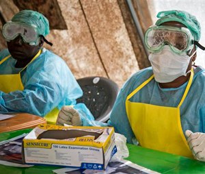 In this Saturday, Aug. 9, 2014 file photo, health workers wearing protective clothing and equipment against the deadly Ebola virus sit in a screening tent at the government hospital in Kenema, eastern Sierra Leone. (AP Photo/Michael Duff, File)