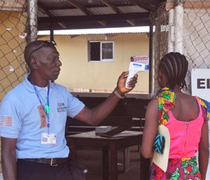 A family member of a 10-year old boy who contracted Ebola has her temperature measured by a health worker before entering the Ebola clinic were the child is being treated. (AP Photo/ Abbas Dulleh)