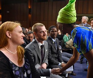 Ebola survivor Dr. Kent Brantly, former Medical Director of Samaritan's Purse Ebola Care Center in Monrovia, Liberia, center, talks with Emira Woods, right, Director of Social Impact at ThoughtWorks, right, before the start of a hearing on Ebola before the Senate Appropriations Subcommittee on Labor, Health and Human Services, and Education on Capitol Hill in Washington, Tuesday, Sept. 16, 2014. Brantly's wife Amber watches at left. Woods thanked Brantly for his work fighting Ebola in Liberia. (AP Photo/Susan Walsh)
