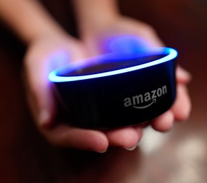 In this Thursday, Aug. 16, 2018, photo a child holds his Amazon Echo Dot in Kennesaw, Ga.
