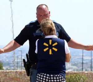 An El Paso police officer talks to a store employee following a shooting at a shopping mall in El Paso, Texas, on Saturday, Aug. 3, 2019.
