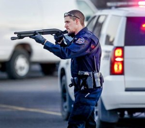 Police go through the parking lot of Excel Industries in Hesston, Kan., Thursday, Feb. 25, 2016.