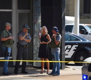 Officials consult near the crime scene at the Huntington Bank, next to the Courthouse in Steubenville, Ohio, Monday Aug. 21, 2017, after Jefferson County Judge Joseph Bruzzese Jr. was ambushed and shot while walking to work early Monday morning.
