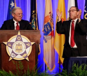 Attorney General Jeff Sessions, left, is applauded by Fraternal Order of Police National President Chuck Canterbury as Sessions addresses the group's convention Monday, Aug. 28, 2017, in Nashville, Tenn.
